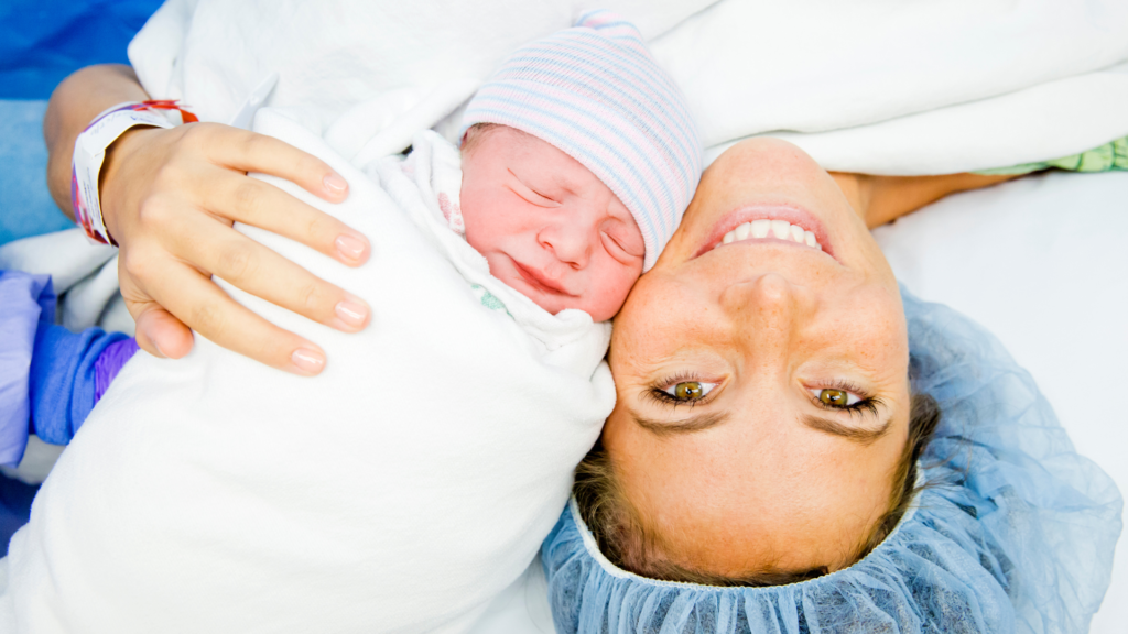 Smiling mama with newborn just after delivery